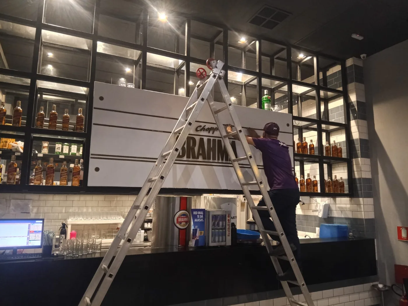 Equipe instalando elementos de comunicação visual na Tasquinha do Tio